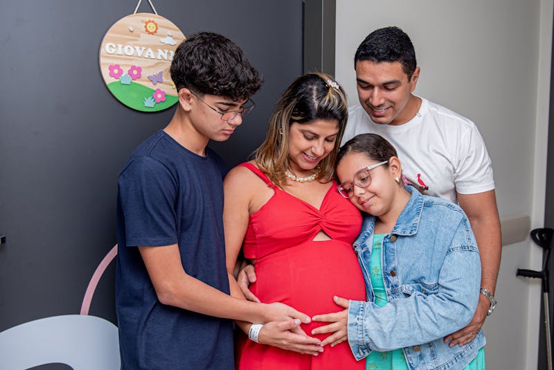 A family embracing an expecting mother