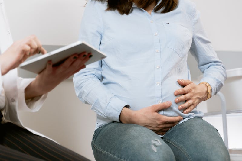 A provider documenting on a tablet during a prenatal visit